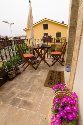 a patio with a table and chairs and flowers at Appartamento Palma Gold in Spello