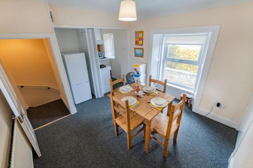 a dining room with a table and chairs and a window at The Garden Cottage in Elgin