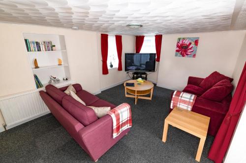 ein Wohnzimmer mit 2 Sofas und einem TV in der Unterkunft The Garden Cottage in Elgin