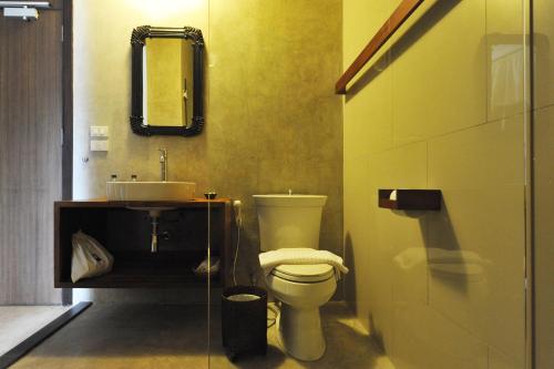 a bathroom with a toilet and a sink and a mirror at Villa Bangkok in Bangkok