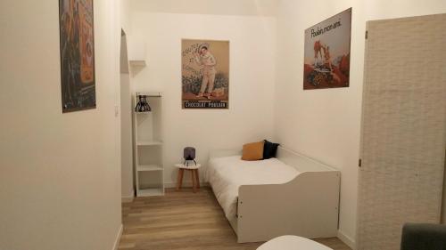 a small bedroom with a bed and posters on the wall at Appartement "POULAIN" en Centre-ville linge inclus in Blois