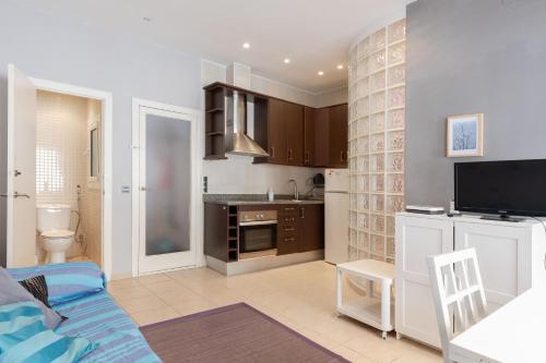 Hauzify I Apartament Subirats في سان فيليو دي غيكسولس: غرفة معيشة مع أريكة ومطبخ