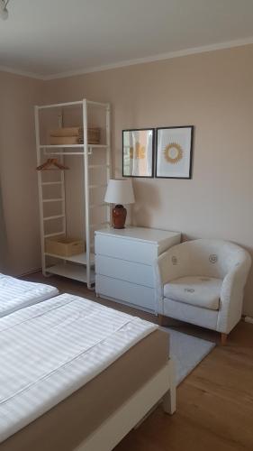ein Schlafzimmer mit einem Bett, einem Stuhl und einer Kommode in der Unterkunft Apartment Graz Murpromenade in Graz