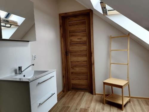 a kitchen with a sink and a wooden door at Apartament z pięknymi widokami, około 900m do przejrzystego jeziora Choczewskiego, blisko morza in Perlino