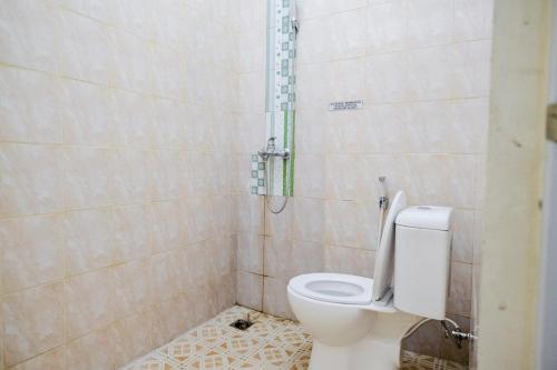 La salle de bains est pourvue d'une douche et de toilettes. dans l'établissement RedDoorz Syariah near Gatot Subroto Lampung 4, à Lampung