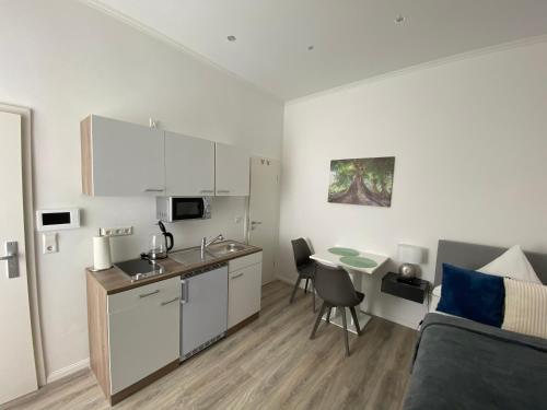 カールスルーエにあるPrime Host Smart Apartmentsのキッチン、リビングルーム(ソファ、テーブル付)