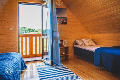 a bedroom with a bed and a window in a cabin at Słonecznikowe Wzgórze in Debina