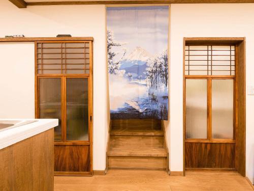 京都的住宿－寧靜之家度假屋，一间设有两扇门的房间,墙上有一幅画