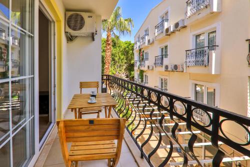 a balcony with wooden tables and chairs on a building at Bossa Nova Apart Hotel in Kaş