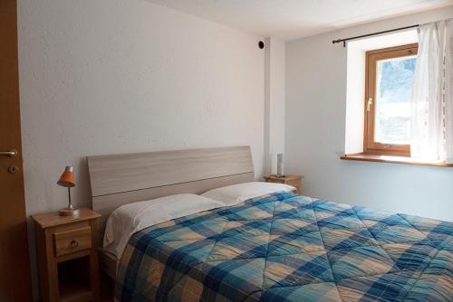 1 dormitorio con cama y ventana en Petit Paradis en Valgrisenche