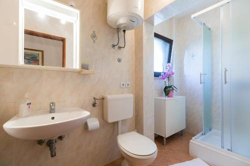 a bathroom with a toilet and a sink and a shower at Apartments Marija in Funtana