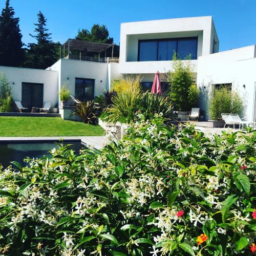 a house with a lot of flowers in front of it at Villa le sud appartements in Cassis