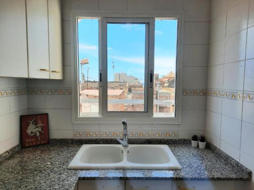 ein Waschbecken in einem Zimmer mit Fenster in der Unterkunft Wanderlust Apartment Old Town in Tarragona