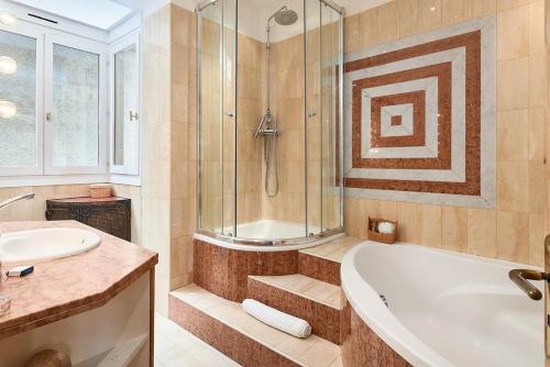 une salle de bain avec une baignoire, une douche et un lavabo dans l'établissement Sunlight Properties - Marinette - Port area, 2 Bedrooms, sleep 6, sea view, à Nice