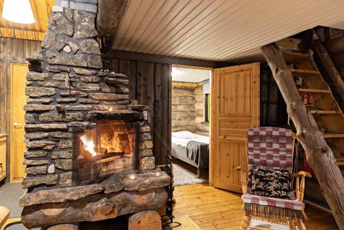 a stone fireplace in a room with a bedroom at Polar Aurora Cabins in Saariselka