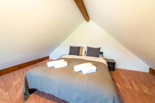 1 dormitorio con 1 cama con 2 toallas en Villa Bella Italia II, en Mikołajki