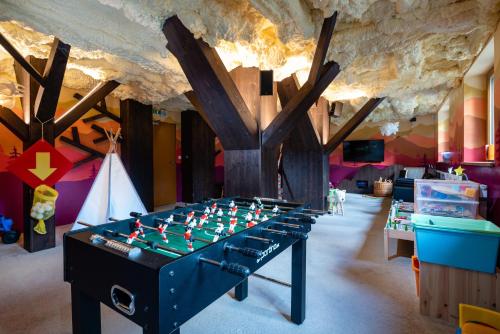 a room with a foosball table in the middle at Hotel Björnson & Björnson TREE HOUSES Jasná in Demanovska Dolina