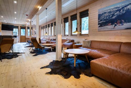 a lobby with a couch and tables and chairs at Hotel Björnson & Björnson TREE HOUSES Jasná in Demanovska Dolina