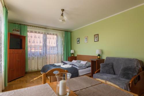 salon z łóżkiem i kanapą w obiekcie Willa Maria w Muszynie