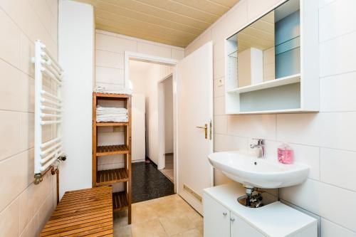 y baño con lavabo y espejo. en Budget Apartments Deutz, en Colonia