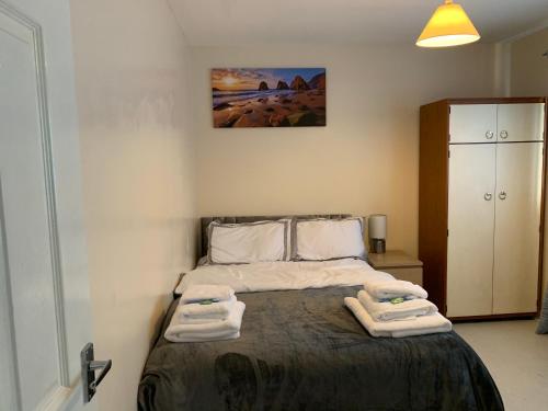 a bedroom with a bed with two towels on it at Dada Apartment in Glasgow