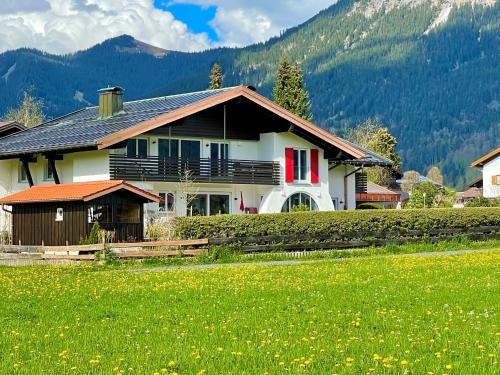 een huis met een groen veld ervoor bij Fellhorn Ferienwohnungen in Oberstdorf