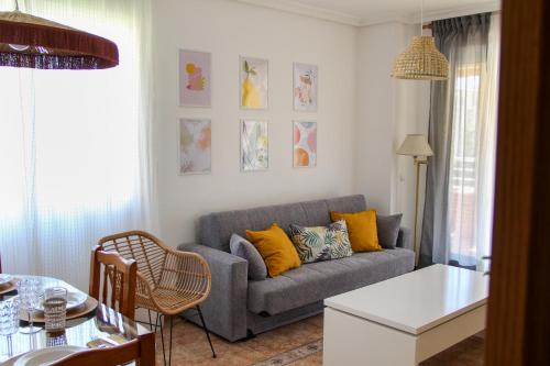 a living room with a gray couch and yellow pillows at Benimar La Cala in Cala de Finestrat