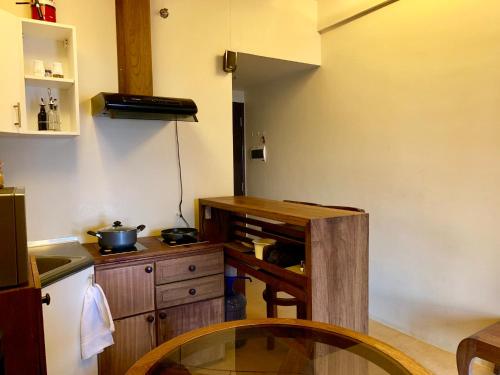 eine Küche mit einem Holztisch und einer Arbeitsplatte in der Unterkunft Penthouse Condo Studio Unit CENTRIO TOWER w/ Stove in Cagayan de Oro