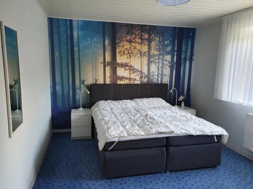 a bedroom with a bed with a painting on the wall at Ferienhaus 7a in Munster im Heidekreis