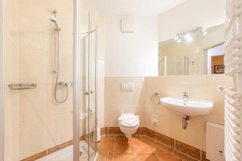 a bathroom with a shower and a toilet and a sink at Residenz an der Prorer Wiek am Kurpark in Binz