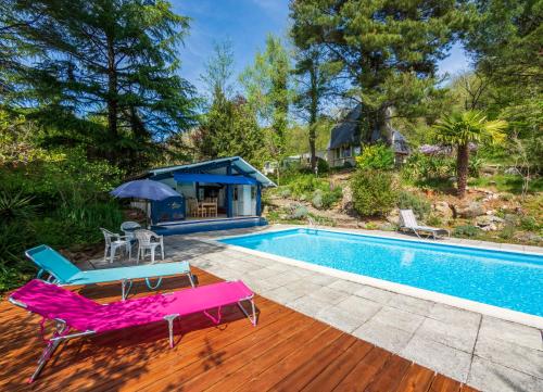 een zwembad met een terras en stoelen en een huis bij Horizons Verts Appartement Cerisier in Puivert