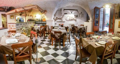 un restaurante con mesas y sillas en una habitación en Hotel Overland, en Toirano