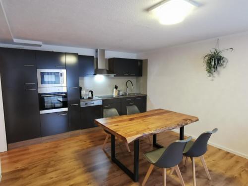 a kitchen and dining room with a wooden table and chairs at FeWo nähe Europapark in Hugsweier