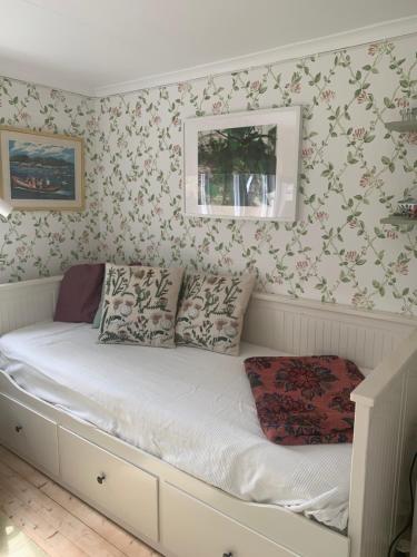 a bed in a room with floral wallpaper at Lyckorna 62:1 in Ljungskile