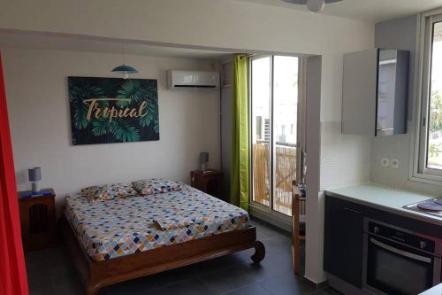 um quarto com uma cama num quarto com uma janela em Le Repère tropical à la Marina em Pointe-à-Pitre