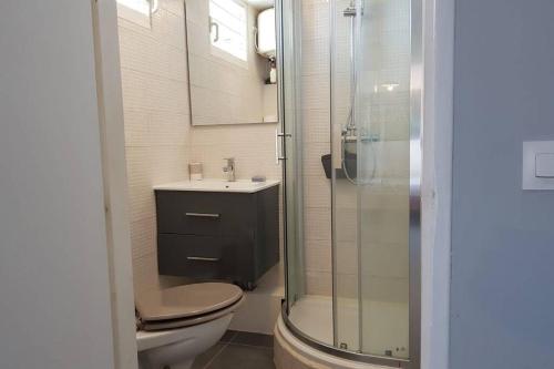 a bathroom with a toilet and a glass shower at Le Repère tropical à la Marina in Pointe-à-Pitre