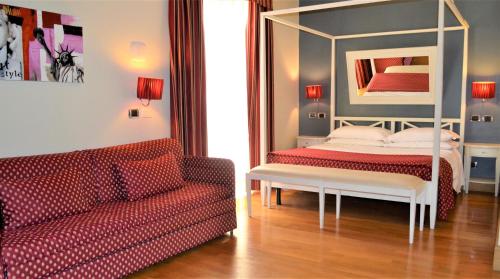 a living room with a bed and a couch at Hotel Fiera Di Brescia in Brescia