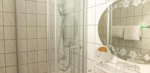 a bathroom with a shower and a mirror at Hotel Garni Zum Hirschen in Iphofen