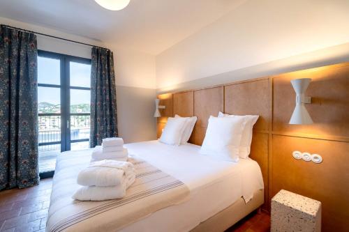 een slaapkamer met een bed met witte handdoeken bij Hôtel Restaurant Villa Joséphine in LʼÎle-Rousse