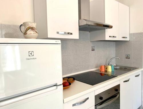 a kitchen with white cabinets and a sink at Case vacanze Miramare in Levanto