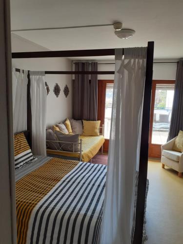ein Schlafzimmer mit einem Bett und einem Sofa in der Unterkunft Les Remparts - chez Dan et Francois in Bénévent-lʼAbbaye