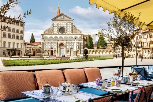 un restaurante con mesas frente a un edificio en The Place Firenze, en Florencia