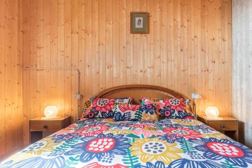 a bedroom with a bed with colorful pillows at Baita Rustica immersa nel verde in Roncone