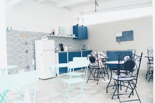 uma cozinha com mesas e cadeiras e um frigorífico em B&B Alto Salento - Pool and Sun em Pulsano