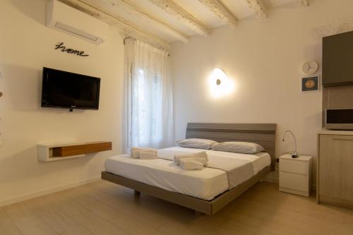 1 dormitorio con 2 camas y TV de pantalla plana en " CASA SAVONAROLA " centro storico en Padua