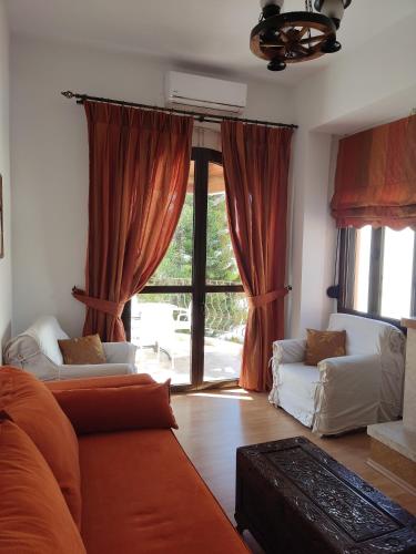 a living room with a couch and a large window at Anemi in Kamilari