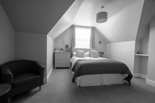 1 dormitorio con 1 cama y 1 silla en Millbrook Guest House en Swanage