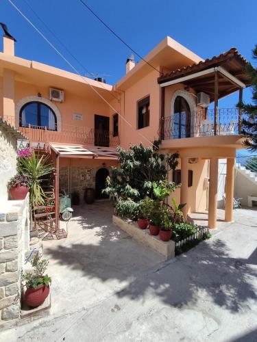 a house with potted plants in front of it at Anemi in Kamilari