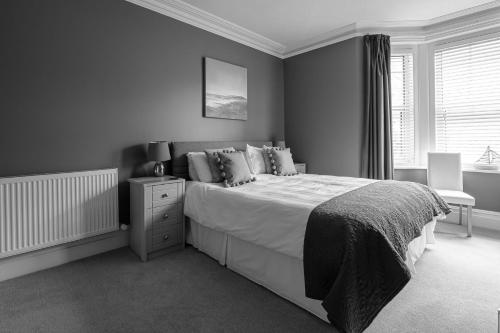 Un dormitorio con una cama grande y una ventana en Millbrook Guest House, en Swanage