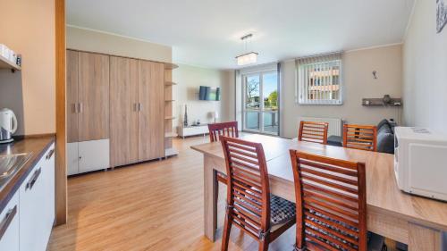 a kitchen with a table and chairs in a room at Bursztynowe Osiedle Jantar, Sun & Snow in Jantar